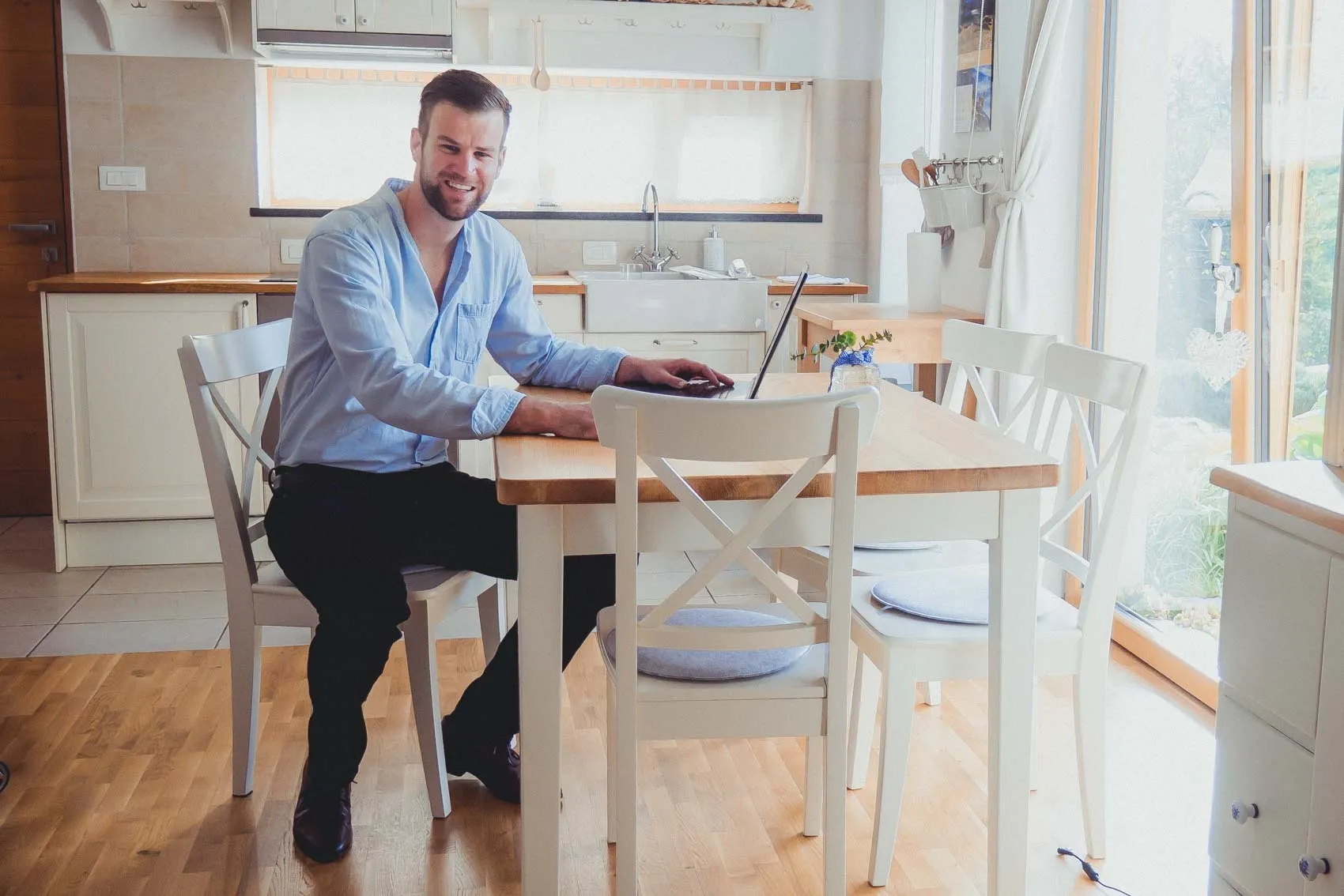Primoz Lazar working on a laptop at a kitchen table