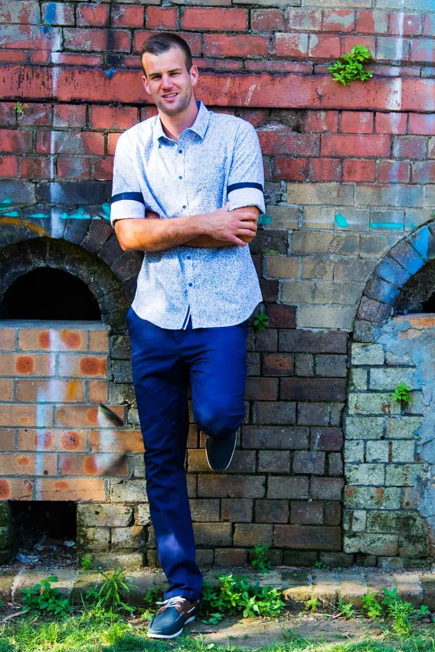 Primoz Lazar leaning against a painted brick wall